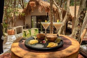 a table with a plate of food and a drink at The Yellow Nest Tulum in Tulum