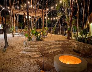 a patio with a table and chairs and lights at The Yellow Nest Tulum in Tulum