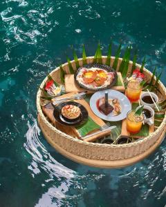 a circular table with food and drinks on the water at The Yellow Nest Tulum in Tulum