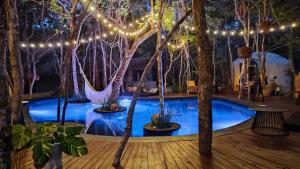 um quarto com uma piscina com árvores e luzes em The Yellow Nest Tulum em Tulum
