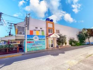 a white building with a sign in front of it at Sweet Caribbean Hotel in San Andrés