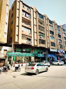 een groot gebouw met auto's geparkeerd voor het bij Hotel SeaView 2 in Karachi