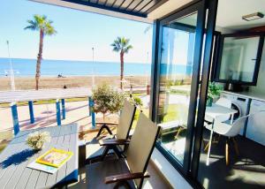 マラガにあるGran vivienda de lujo frente al marのビーチの景色を望むバルコニー(テーブル、椅子付)
