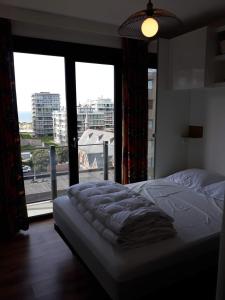 una camera da letto con un letto e una grande finestra di Le char à voile a De Panne