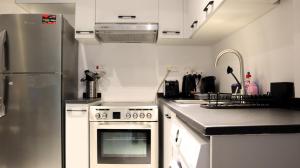 una cucina con piano cottura e frigorifero di Desert Rose Apartment- Masdar City a Al Qurayyah