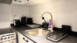 una cucina con lavandino, piano cottura e lavandino di Desert Rose Apartment- Masdar City a Al Qurayyah