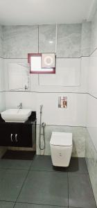a bathroom with a toilet and a sink at Hotel Royal Wings in Elūr
