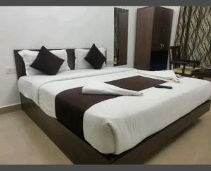 Hotel Shivam Inn - Near Calangute Beach في كالانغيُت: غرفة نوم بسرير كبير وعليها لاب توب