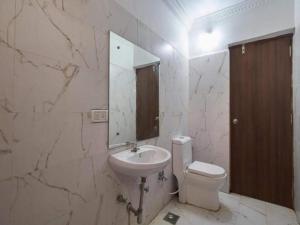 a bathroom with a sink and a toilet and a mirror at Hotel Shivam Inn - Near Calangute Beach in Calangute