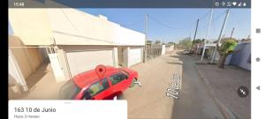 czerwony samochód zaparkowany na boku budynku w obiekcie LOS Teros dptos w mieście Villa María
