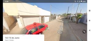 a red car parked on the side of a building at LOS Teros dptos 3 5 3 4 0 9 2 8 1 5 in Villa María
