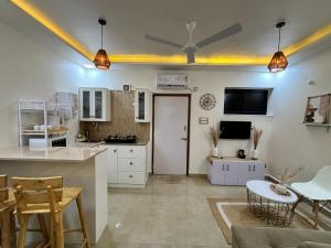 eine Küche mit weißen Schränken sowie einem Tisch und Stühlen in der Unterkunft Vihaa - a boutique stay in Velha Goa