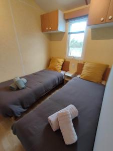 ein Zimmer mit 2 Betten und Handtüchern darauf in der Unterkunft Mobilhome 1 