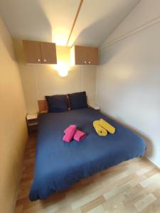 ein Schlafzimmer mit einem blauen Bett mit zwei Handtüchern darauf in der Unterkunft Mobilhome 1 