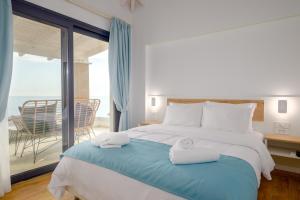 a bedroom with a large bed with towels on it at Vrachos Luxury Maisonettes in Preveza