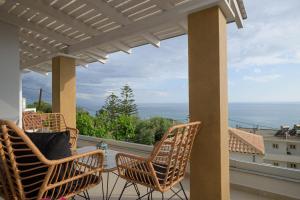 two chairs on a balcony with a view of the ocean at Vrachos Luxury Maisonettes in Preveza