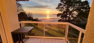 a balcony with a bench and a view of the ocean at Appartement les pieds dans l'eau in Saint-Cast-le-Guildo