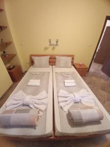 two beds in a room with towels on them at Apartment Amaliya with two bedrooms in Burgas City