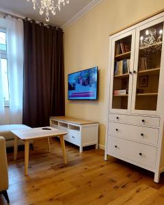 a living room with a white cabinet and a coffee table at Old Town Comfort in Tarnów
