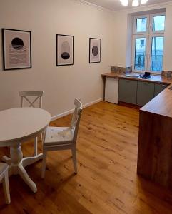 a room with a table and chairs and a kitchen at Old Town Comfort in Tarnów