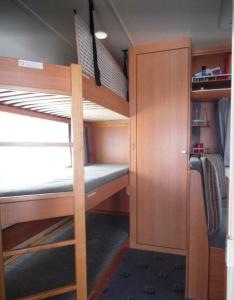 a small room with two bunk beds and a closet at Wohnwagen mit festem Vorzelt - all incl. in Fehmarn