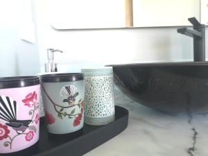 a bathroom with two cups on a shelf next to a sink at Kahurangi Cottage Twizel in Twizel