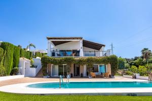 a villa with a swimming pool in front of a house at Villa Pugna - Private Pool, BBQ, Sauna in Benalmádena