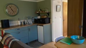 a kitchen with a counter and a clock on the wall at Cedar Cabin Holiday Let - Kinver in Stourbridge