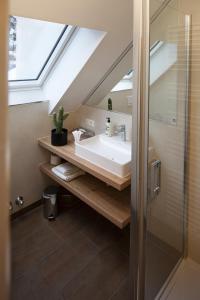 a bathroom with a sink and a skylight at hideauts hotels Der Rosengarten in Füssen