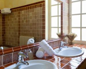 een badkamer met 2 wastafels en een spiegel bij Hôtel le Centenaire in Les Eyzies-de-Tayac