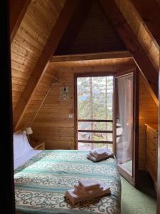 a bedroom with a bed and a window in a cabin at Chalet Natura Sport&Relax in Cavaliere