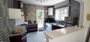a kitchen with black and white wallpaper and a refrigerator at L&B Pereire Arcachon 6 pers, 700m plage Pereire in Arcachon +14 photos