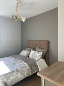 a bedroom with a bed and a wooden table at LuxuryJo BnB - Chambre dans un appartement spacieux et charmant in Roanne