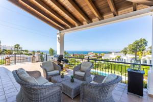 a patio with chairs and tables on a balcony at Villa Pugna - Private Pool, BBQ, Sauna in Benalmádena