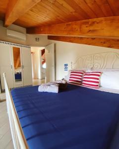 - une chambre dotée d'un grand lit bleu avec des oreillers rouges et blancs dans l'établissement Il Mare in Mansarda, à Agropoli