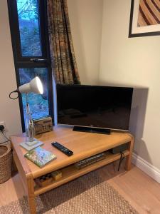 - un salon avec une grande télévision à écran plat et une table basse dans l'établissement Cedar Cabin Holiday Let - Kinver, à Stourbridge