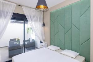 a bedroom with a white bed and a green headboard at Casa Blanca Tenerife in Playa de San Juan