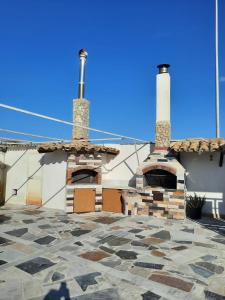 a building with two chimneys and a stone courtyard at VILLA MOGUNTIA in Ficarazzi