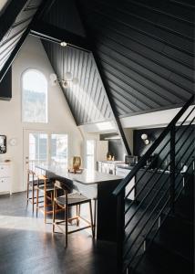 una cocina en el ático con una mesa larga y sillas en Modern A-Frame - Mountain Views - Evergreen, en Evergreen