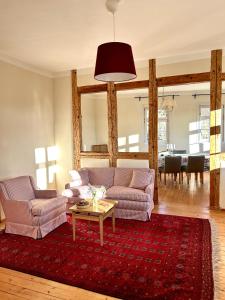 a living room with two couches and a red rug at Ferienwohnung Schloss Heldritt in Bad Rodach