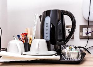 a black coffee maker on a tray on a table at Divine Stay in Coventry