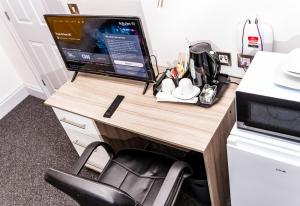 a desk with a computer monitor on top of it at Divine Stay in Coventry