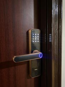 a close up of a door handle with a cell phone at Aqua Inn - Studio Apartment in Greater Noida