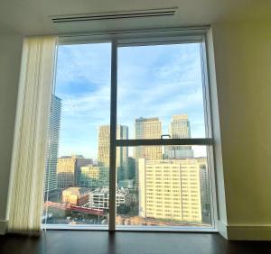 a large window with a view of a city at Luxury Modern 2 Bed Flat with Balcony + City View - Canary Wharf City Center in London