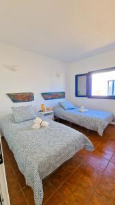 1 dormitorio con 2 camas y ventana en El Levante, en Caleta de Sebo
