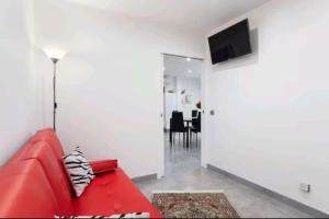 a red couch in a living room with a television at Gite Mare e Montagne Drap 06 in Drap