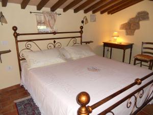 una camera da letto con un letto e un piumone bianco di Casa Vacanze Le Antiche Pietre a Ortignano Raggiolo