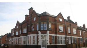 a large red brick building with white windows at Divine Stay in Coventry