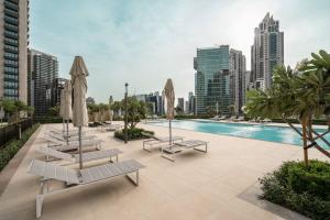 uma piscina com espreguiçadeiras e guarda-sóis numa cidade em Prime Retreats @ Burj Crown by Emaar, Downtown dubai em Dubai