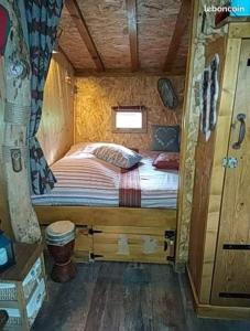 a bed in a small room in a cabin at La cabane perchée du trappeur in Écrainville